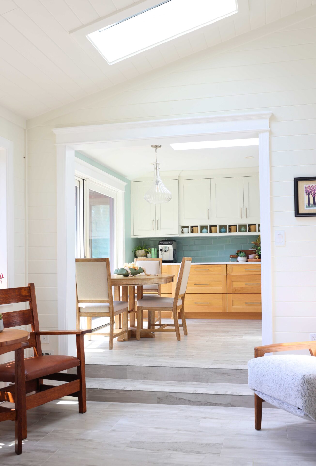 New enclosed porch area with steps going up the kitchen table and coffee bar