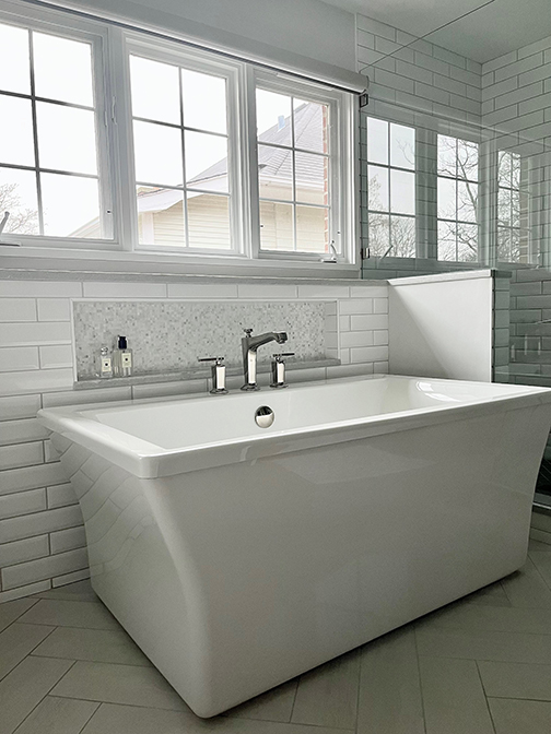 White freestanding bath tub with tub niche, white subway tile