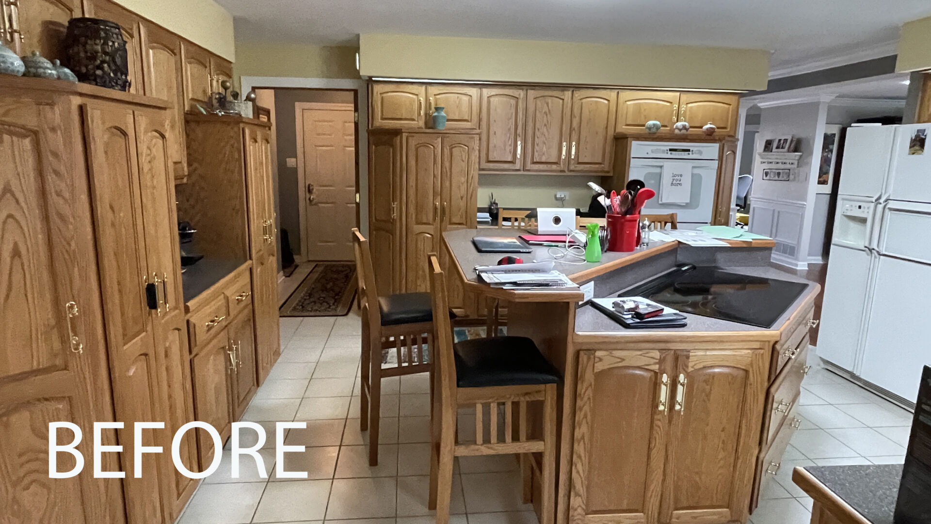 Honey oak kitchen island and perimeter cabinets, white appliances