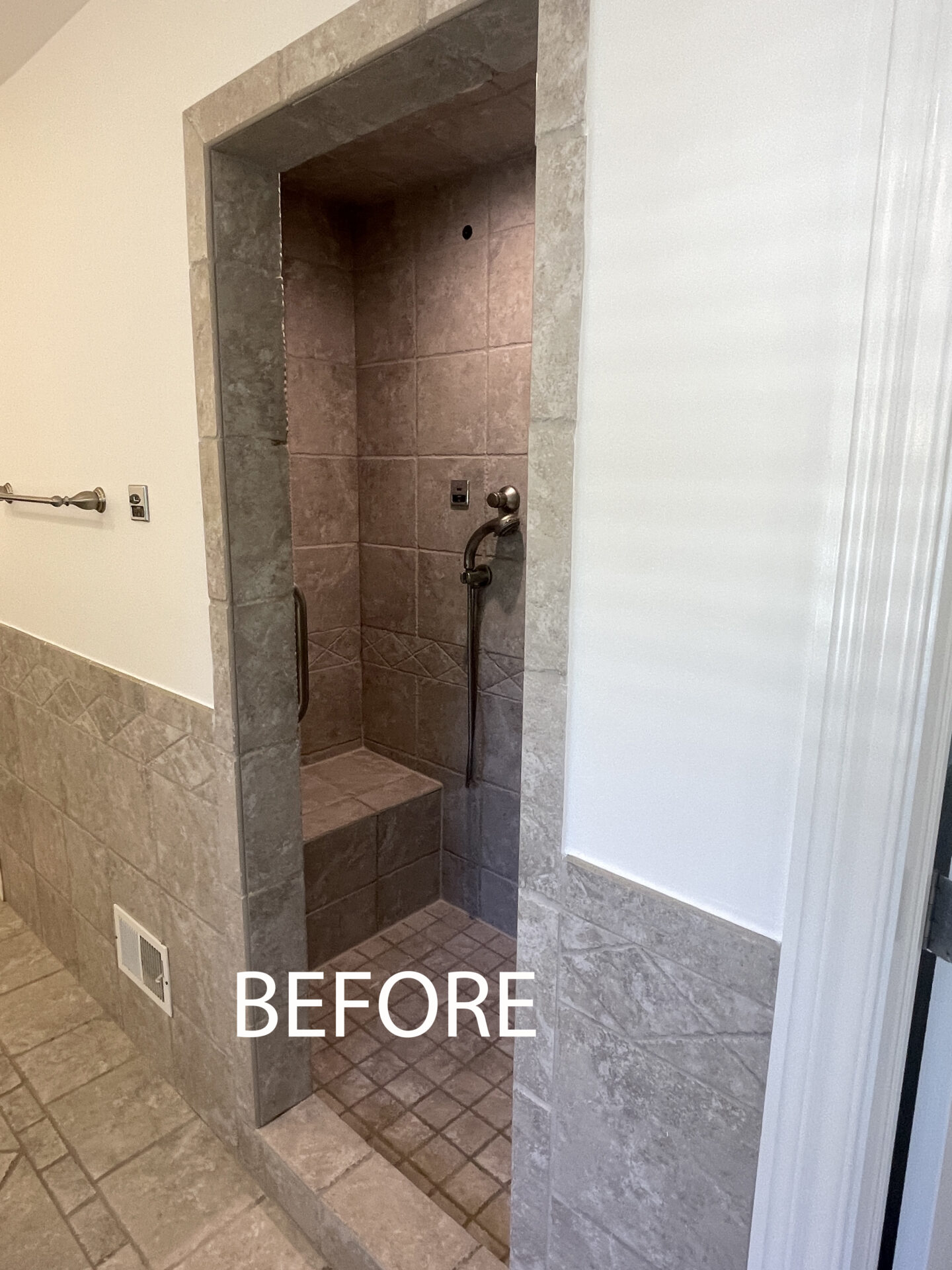 Before shower photo, cavern-like enclosed shower with shower bench