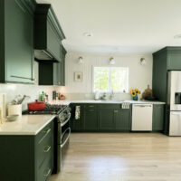 Forest green kitchen with white beadboard, and quartz range backsplash