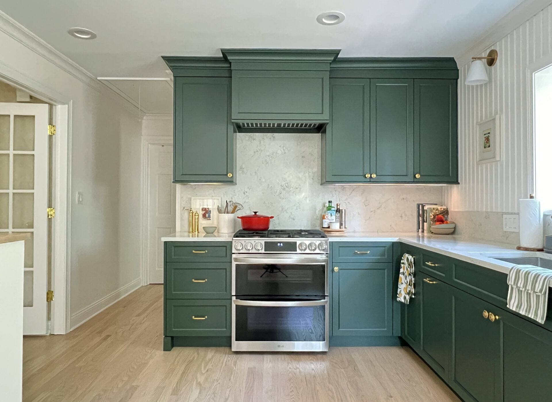 Kitchen with stained island and lower cabinets, blue/green painted upper cabinets. Featuring subway tile and quartz countertops