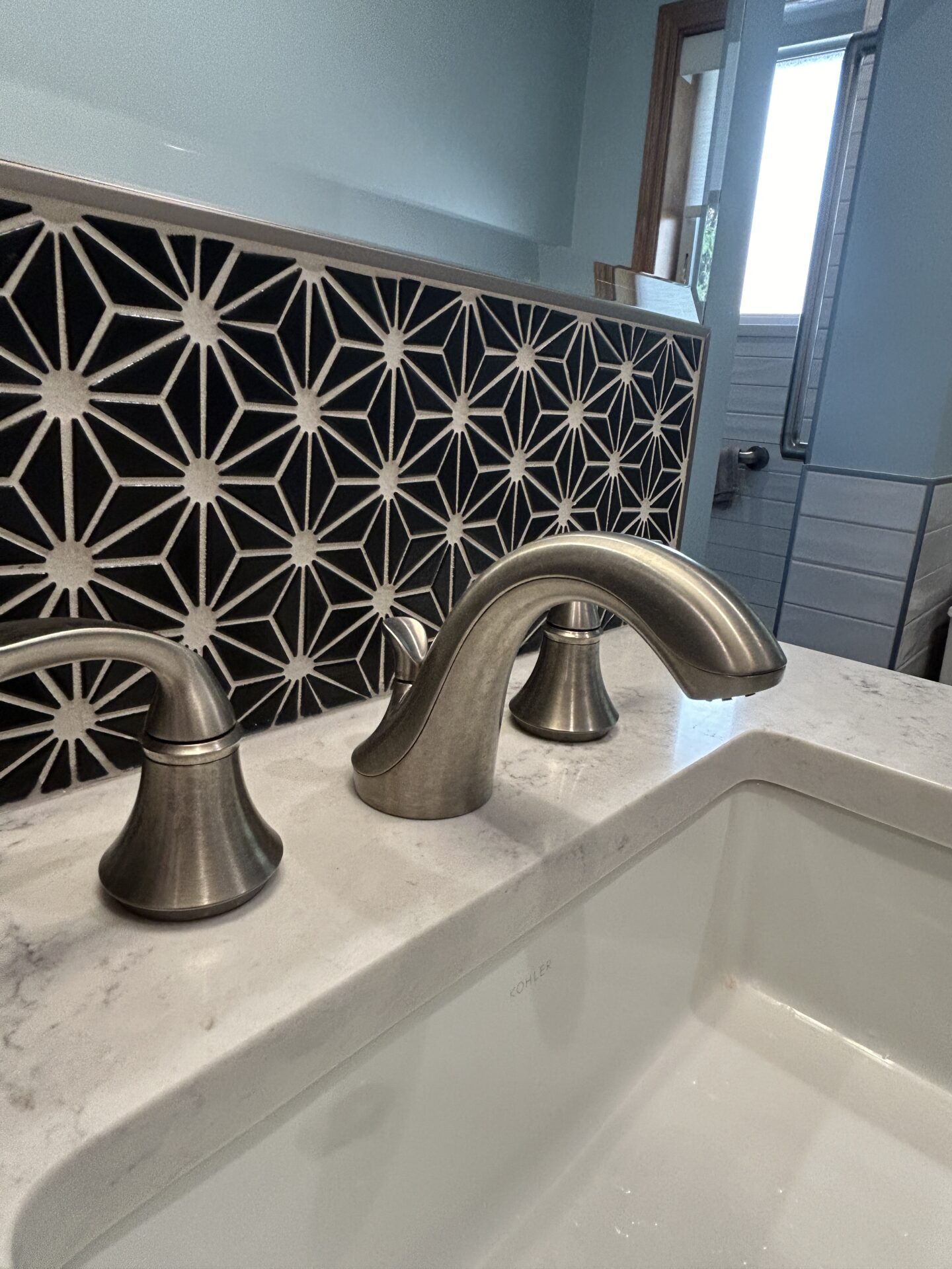 Black and white rhomboid tile above bathroom sink