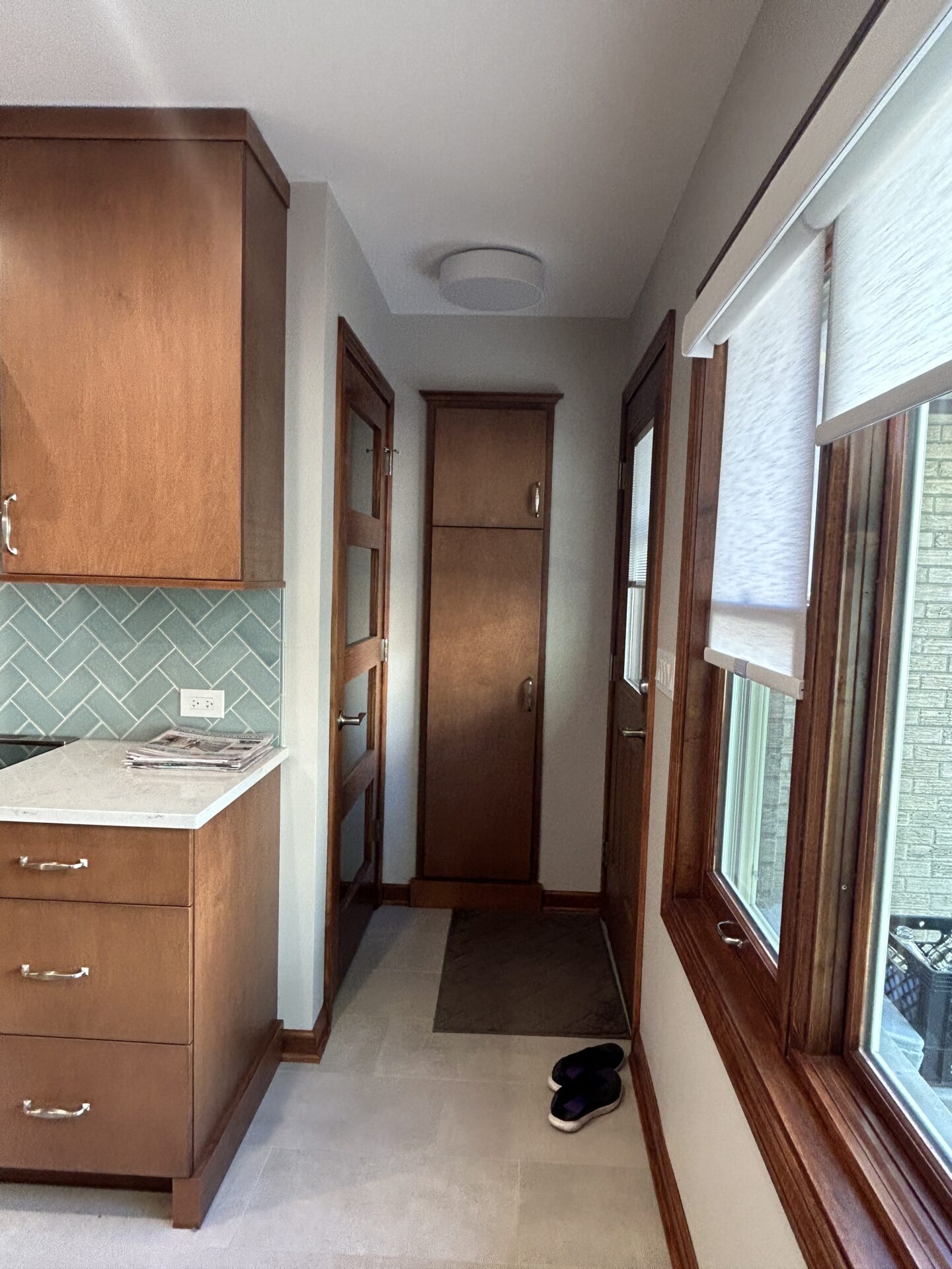Maple cabinetry and doorways in kitchen, light blue green tile backsplash