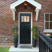 Back door to the home features a covered entry and a black door