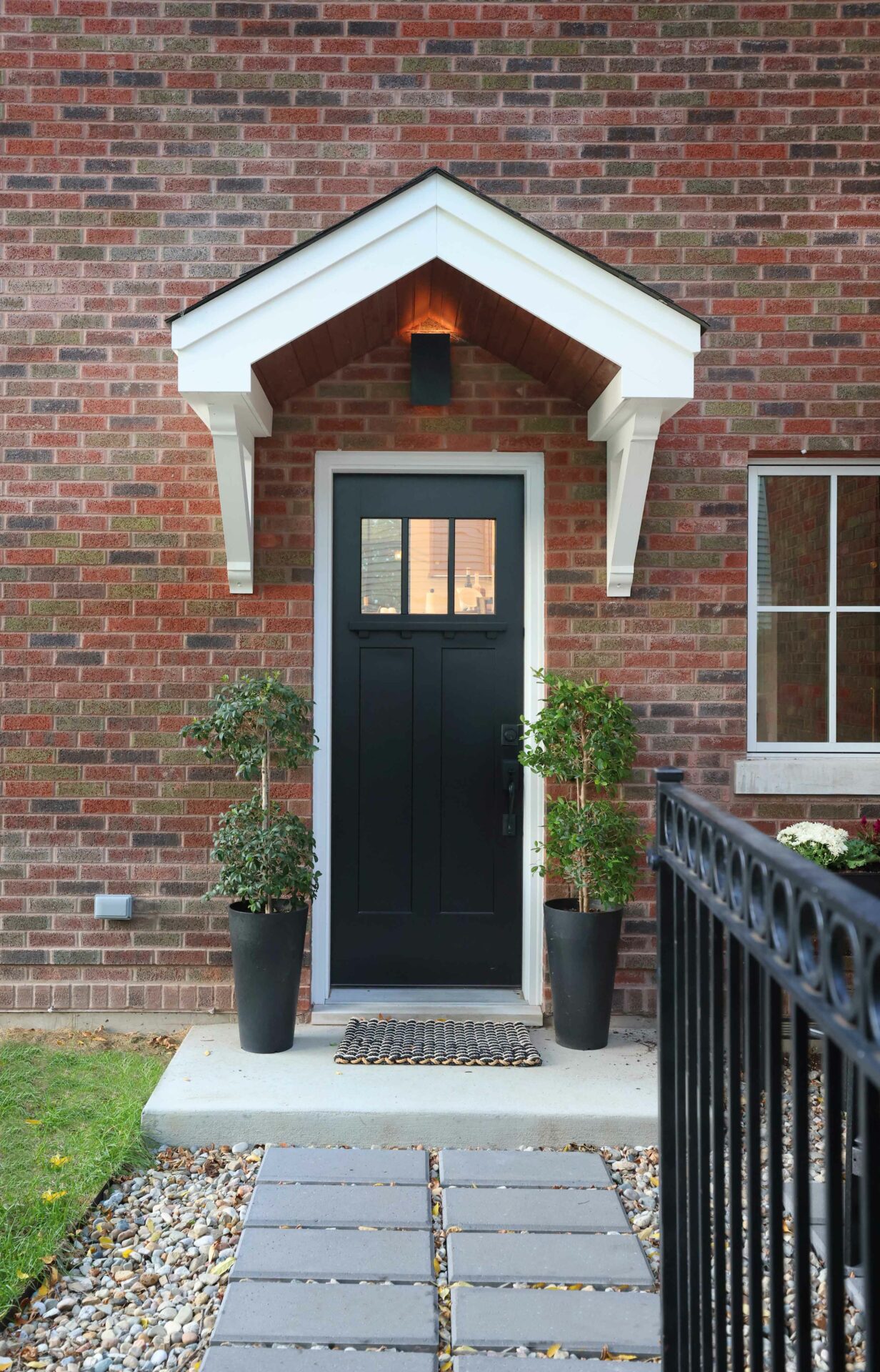 Back door to the home features a covered entry and a black door