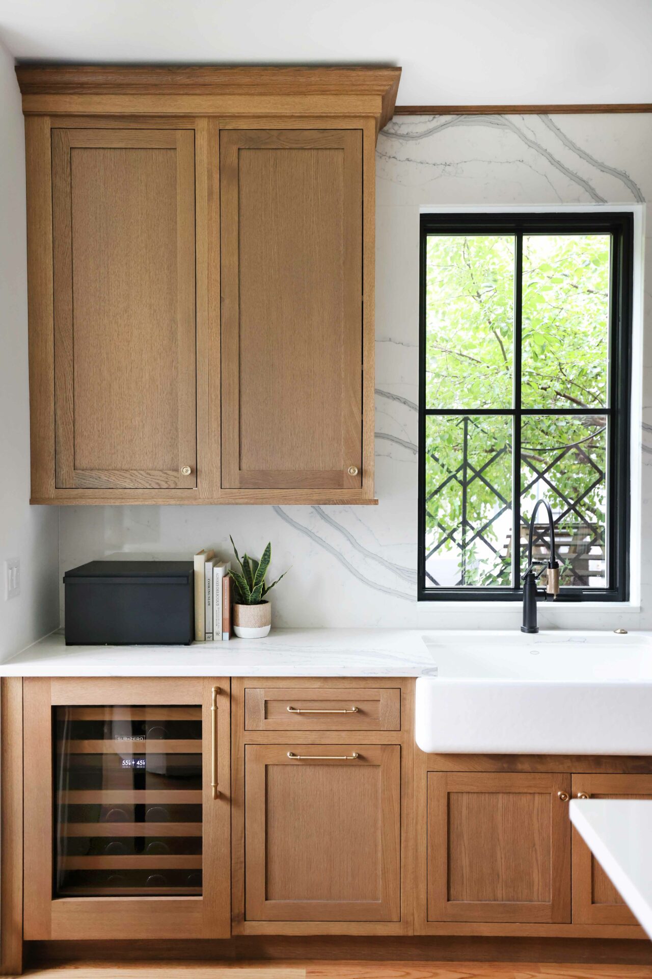 Rift cut white oak kitchen with full height slab backsplash and black trimmed windows