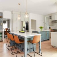 Warm white kitchen with two gray islands and home bar