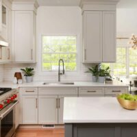 Warm white kitchen with gray island and undermount sink