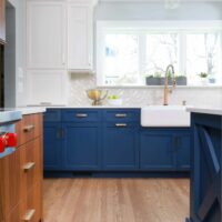 Tri-tone kitchen with walnut cabinets, blue cabinets, and white cabinets