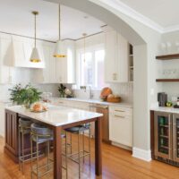 Ivory painted kitchen cabinets with stained walnut island
