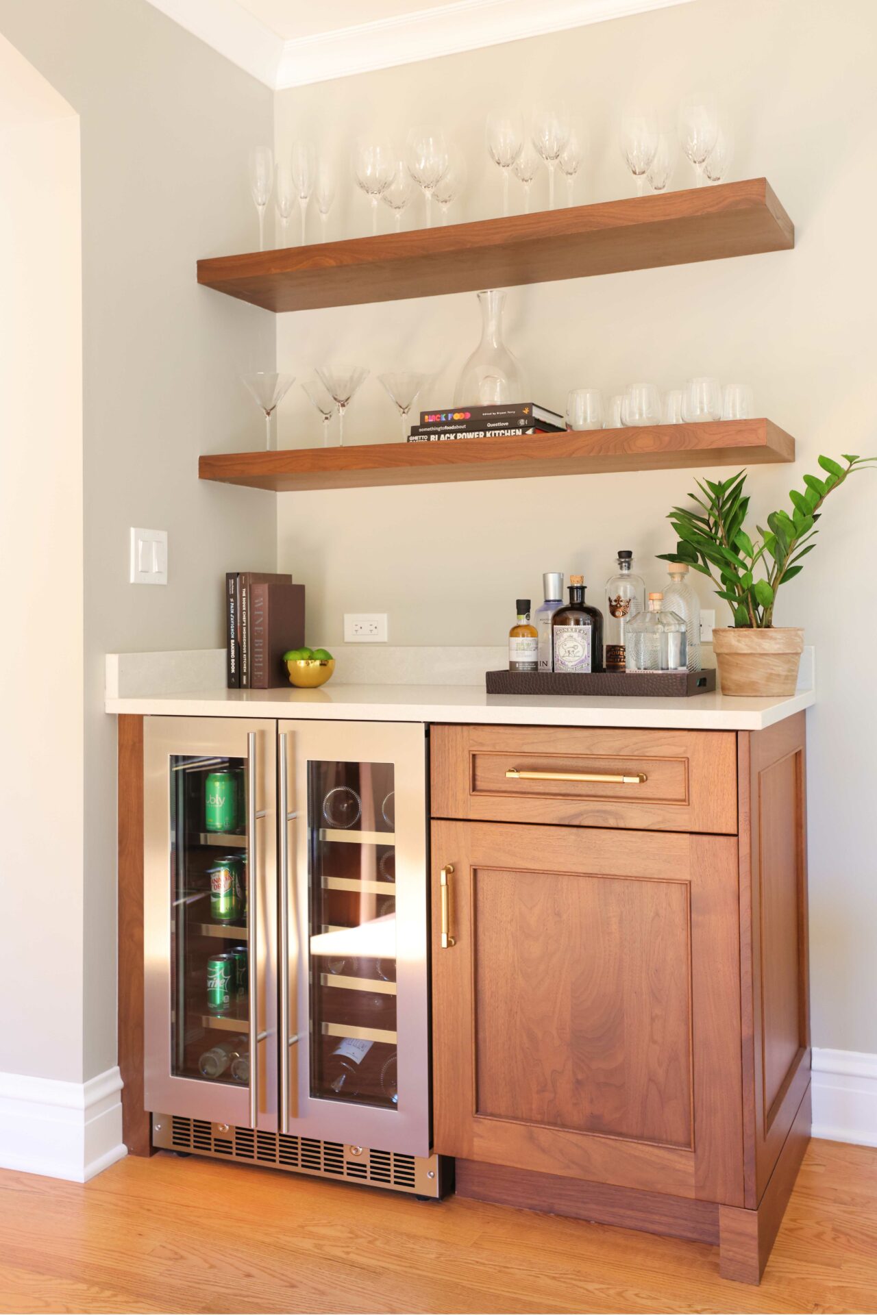 Home dry bar with walnut cabinetry and floating shelves
