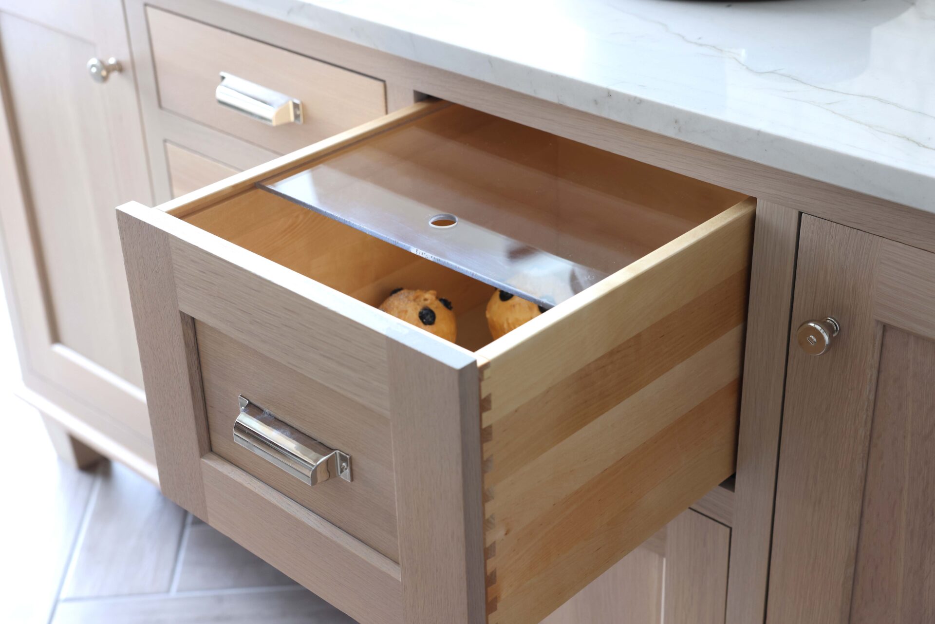 Rift cut white oak kitchen island with polished nickel hardware and bread drawer