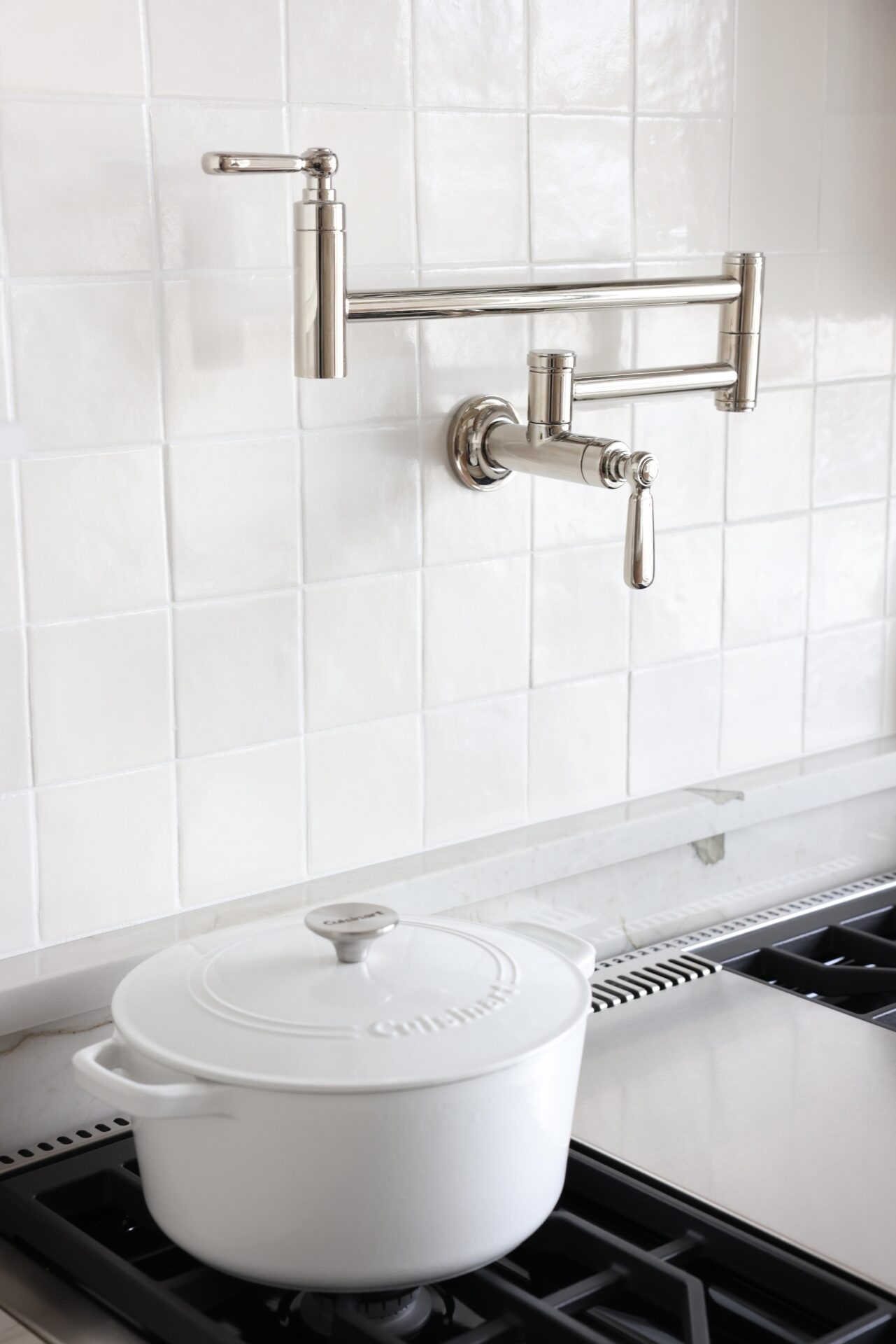 Polished nickel pot filler and white zellige tile backsplash