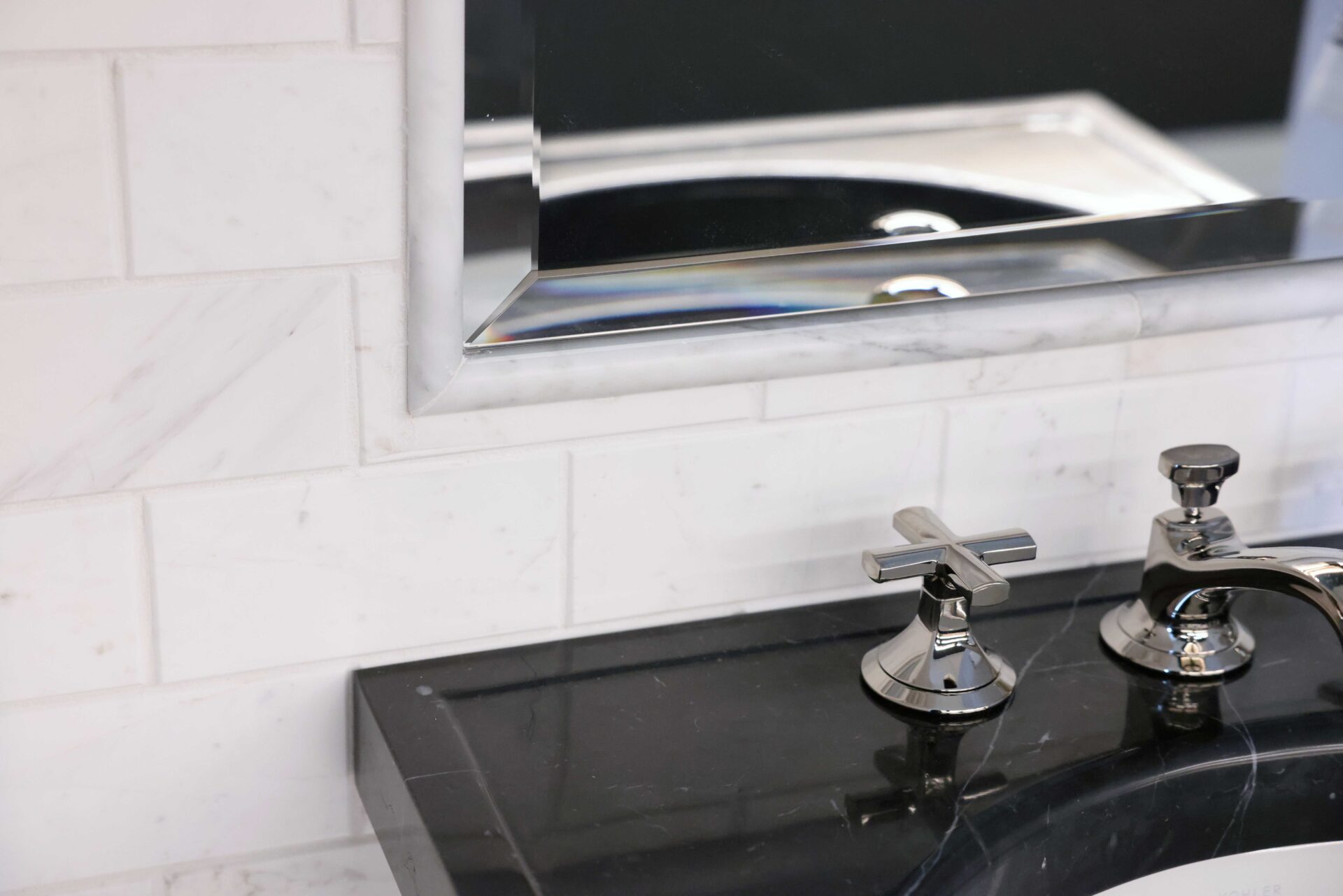 Marble sink, marble backsplash in powder room. Polished nickel faucet, beveled mirror edge