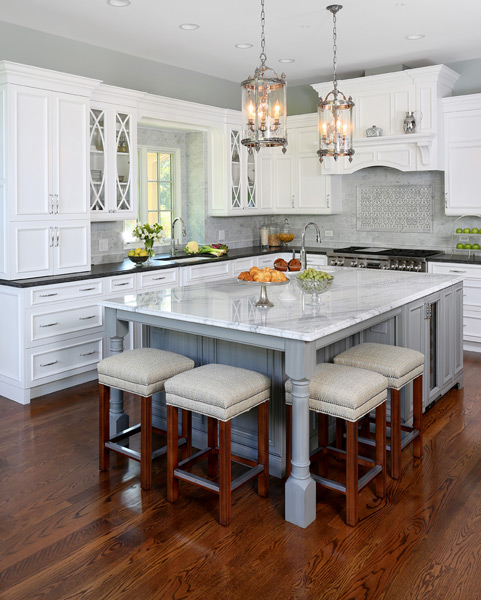 traditional style white kitchen cabinets with a gray center island