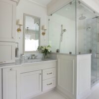 traditional bathroom in light gray with separate vanities and separate bathtub and shower