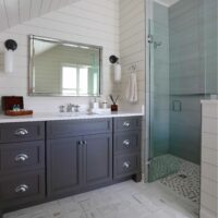 bathroom with roll in shower and dark vanity