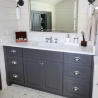 farmhouse style bathroom with dark vanity and white shiplap walls