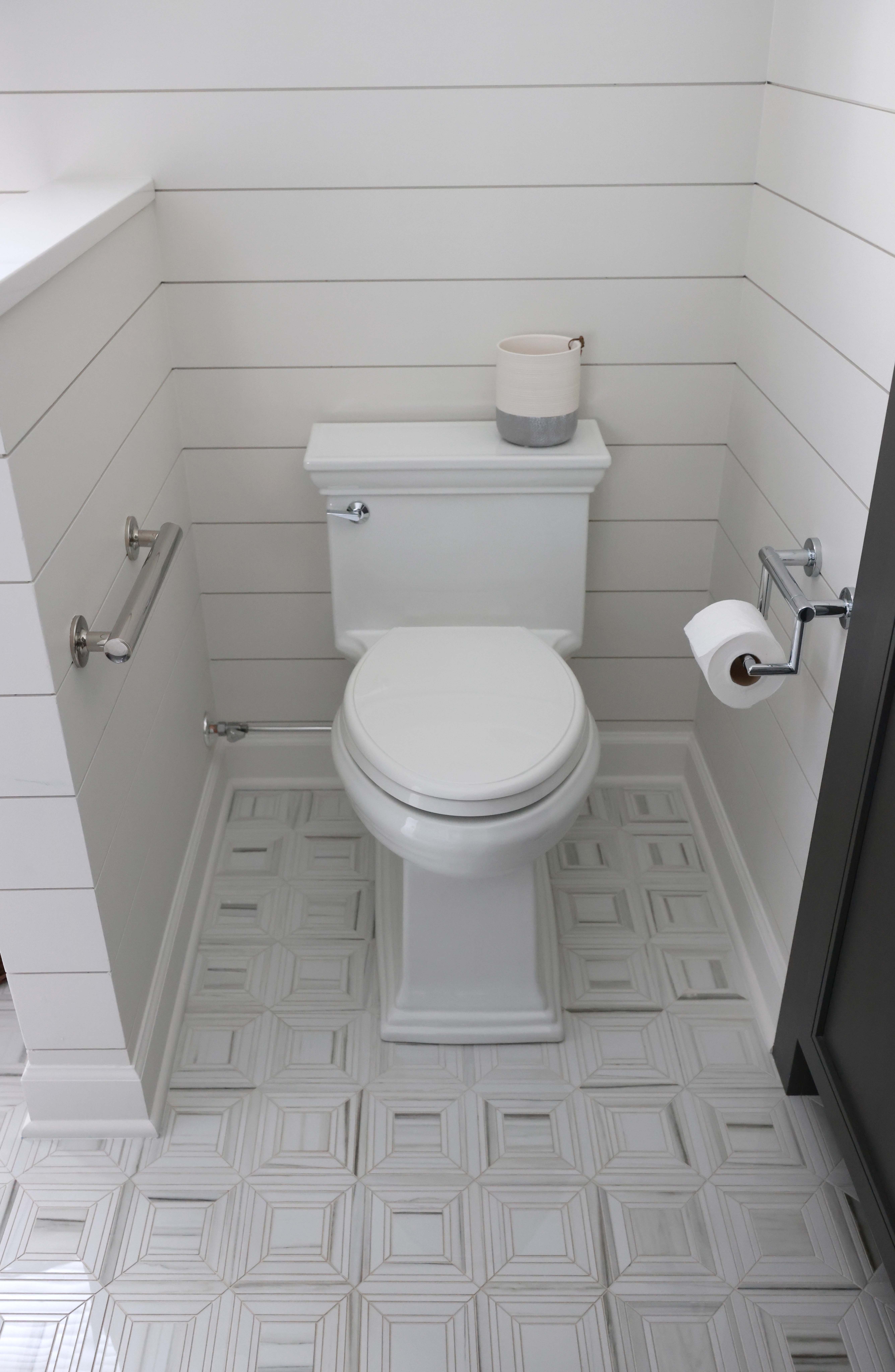 farmhouse style bathroom with grab bars near the toilet