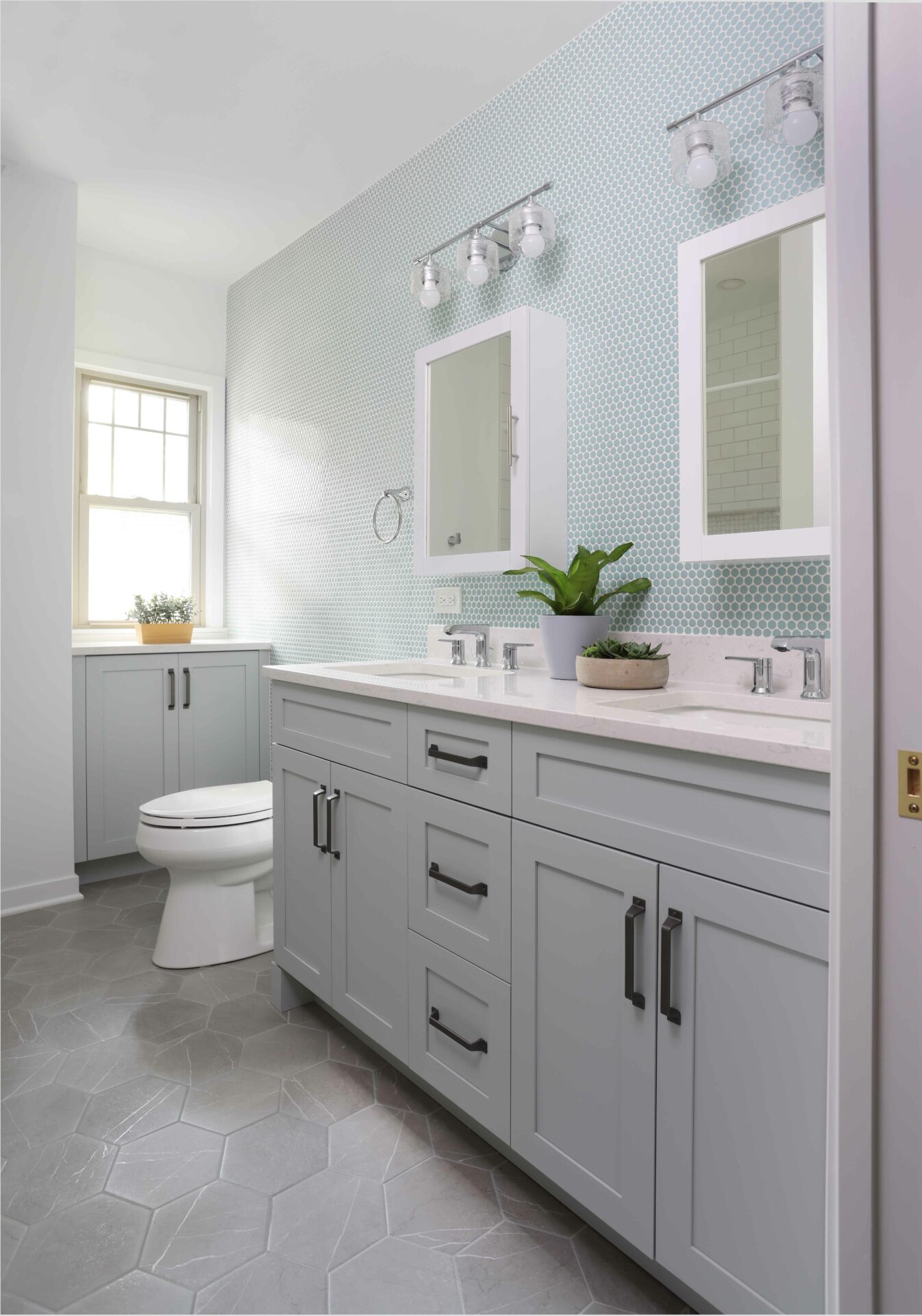 Hall bathroom with gray painted cabinet and penny tile on the walls