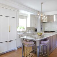 hickory island and stainless steel hood range, paneled fridge, quartz countertop and window above the sink