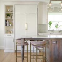 paneled fridge and hickory island in white kitchen