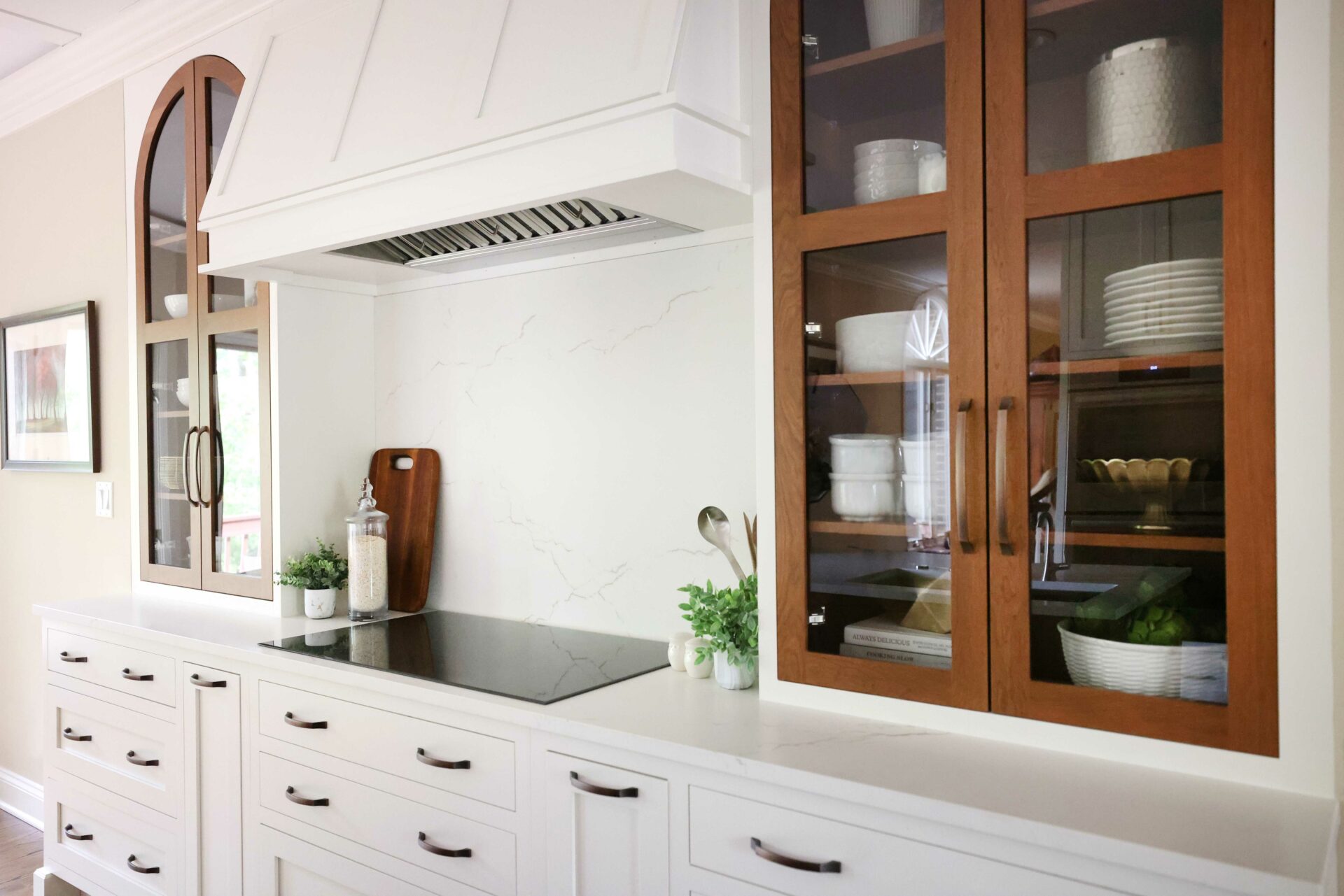 White kitchen with contrasting cherry cabinets flanking the cooking surface