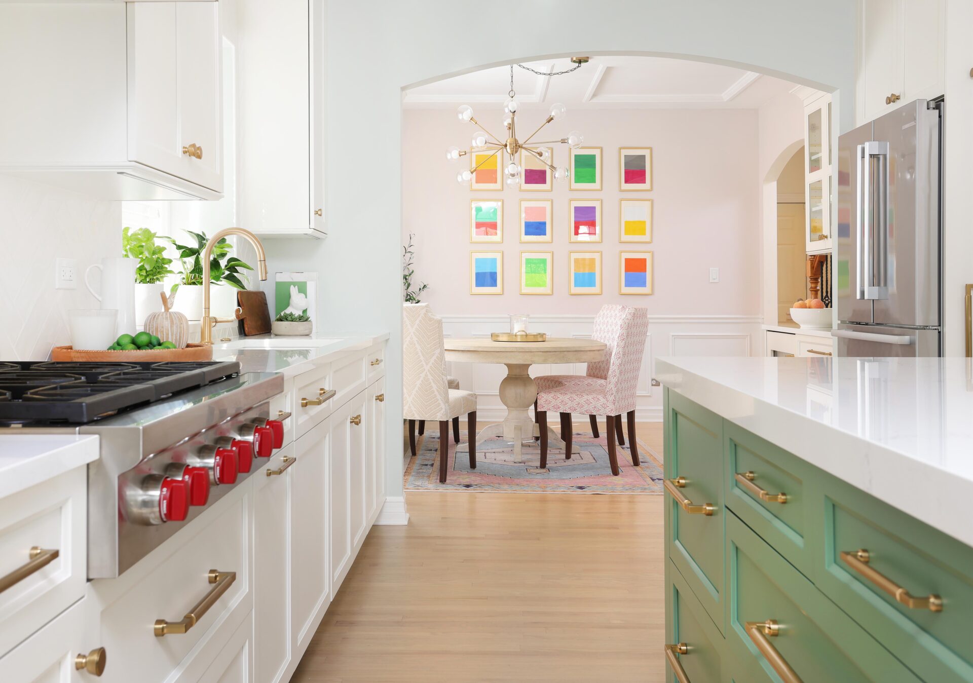 White kitchen with green island looking into colorful dining room