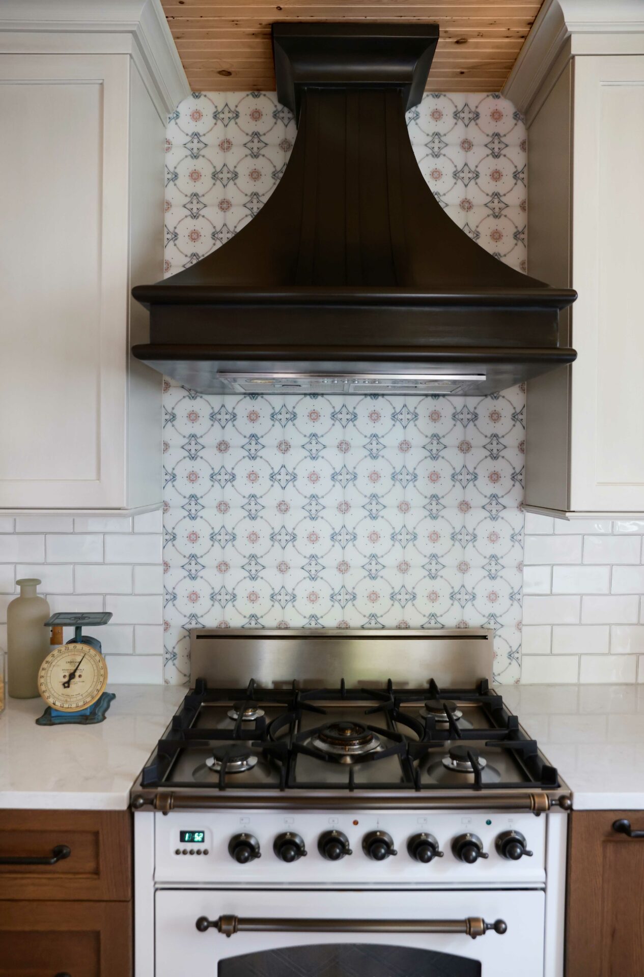 sloping metal hood above white range