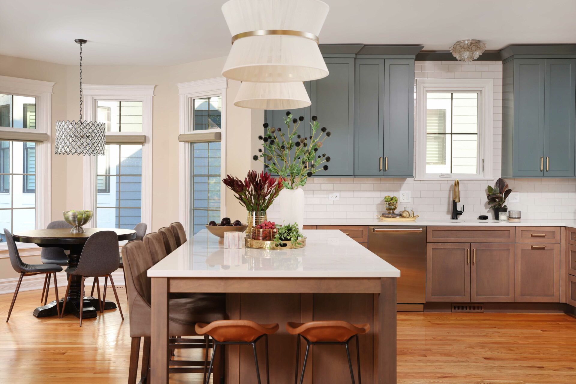 Kitchen with stained island and lower cabinets and blue - green painted upper cabinets