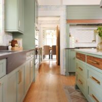 Green kitchen walnut inset drawers on kitchen island, quartz countertop apron style sink