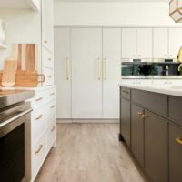 modern off-white kitchen with dark painted island is filled with classic details