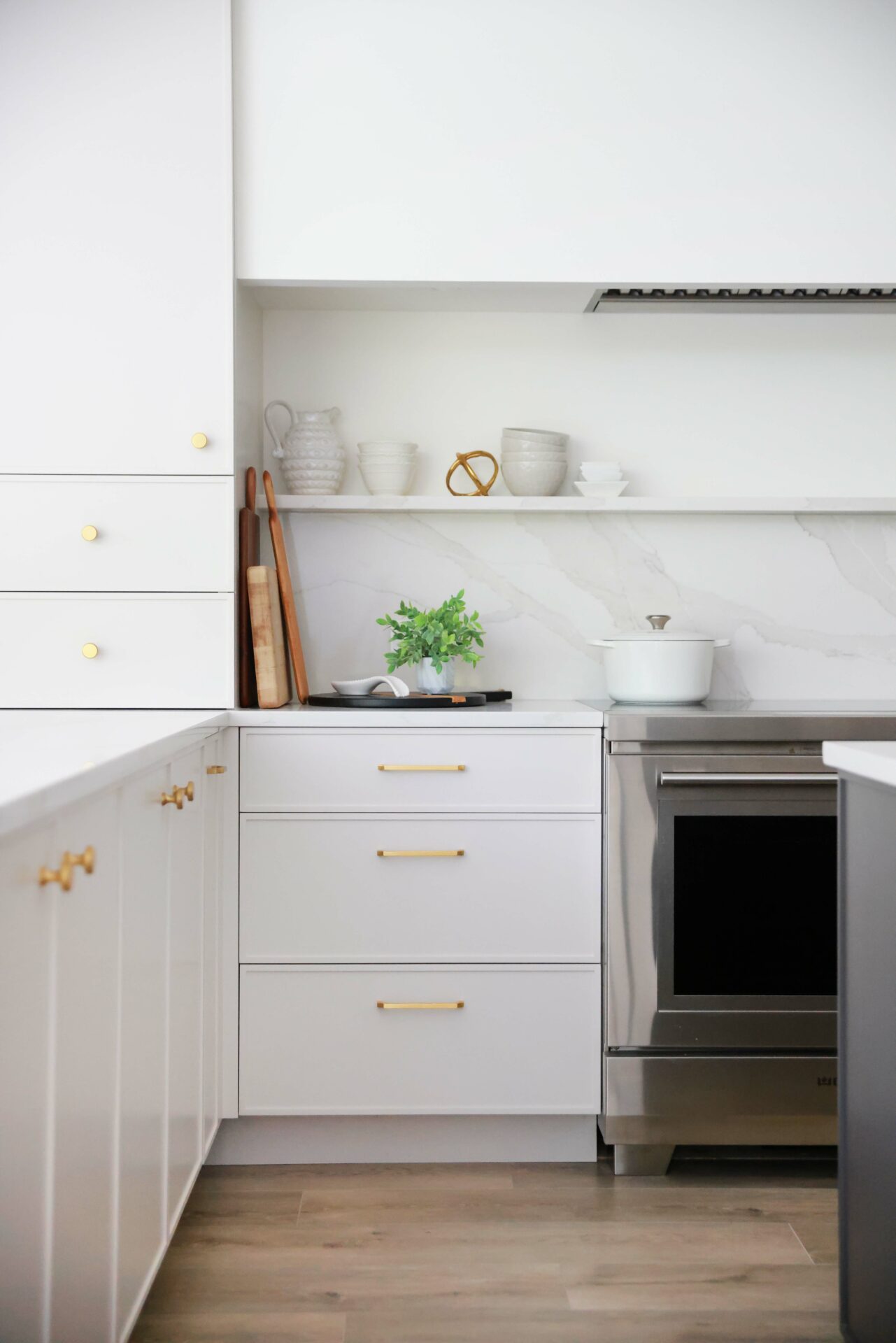 White modern kitchen with slab backsplash and shelf above the range