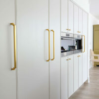 soft white kitchen cabinetry including paneled appliances