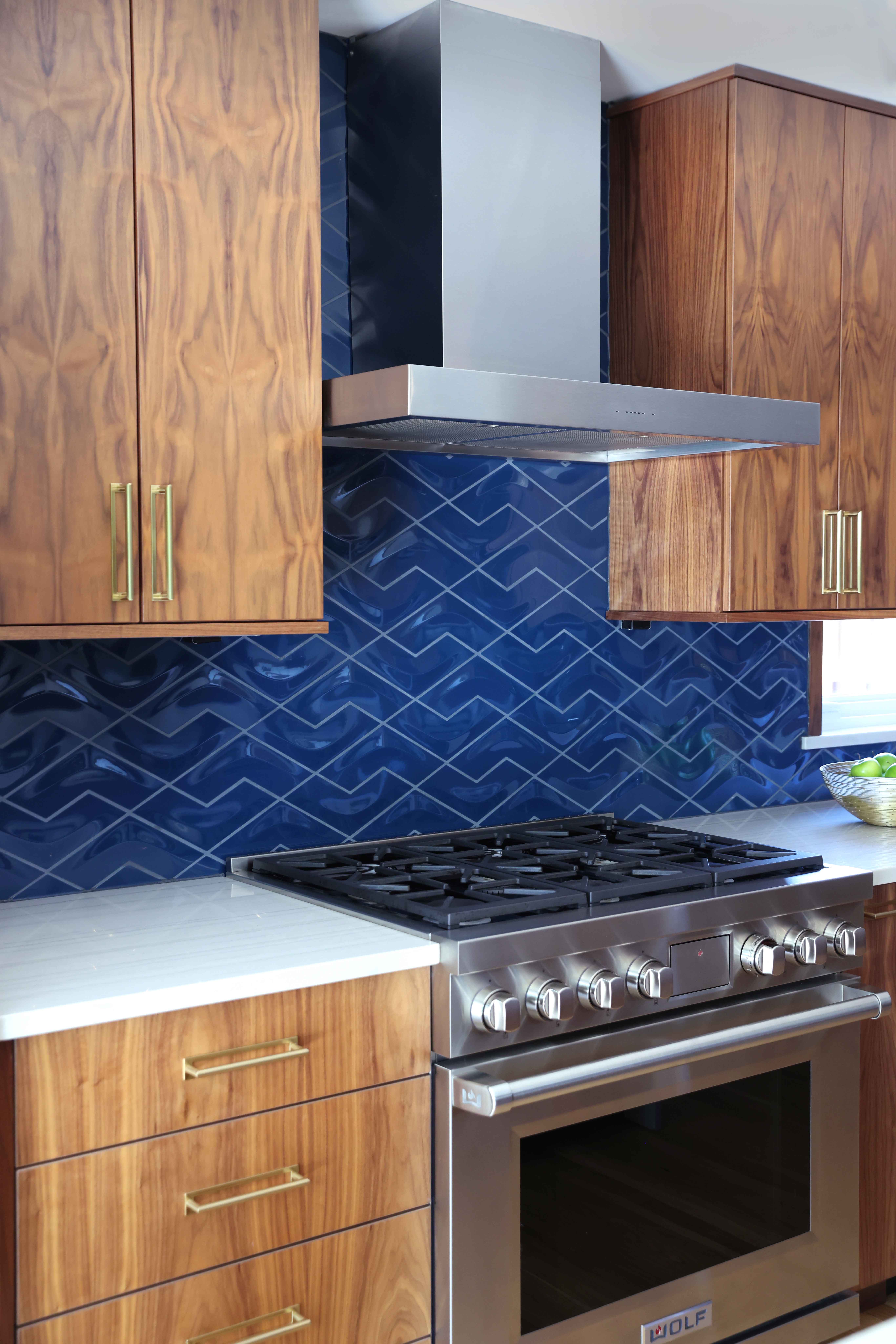 mid century modern kitchen with stained cabinets and blue backsplash tile