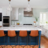white kitchen with bold blue island and soft blue backsplash tile