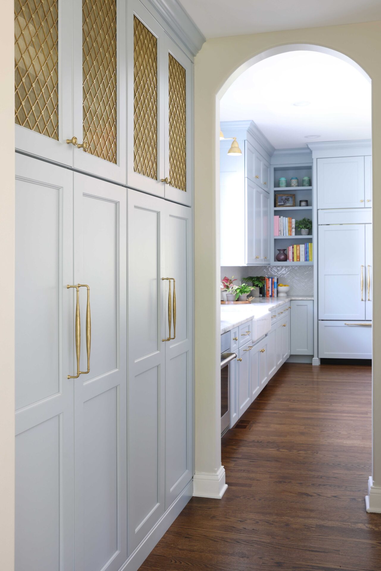 Butler's pantry with gold tone mesh cabinet door inserts