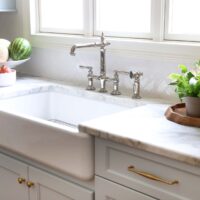 White apron front sink in a light blue traditional kitchen