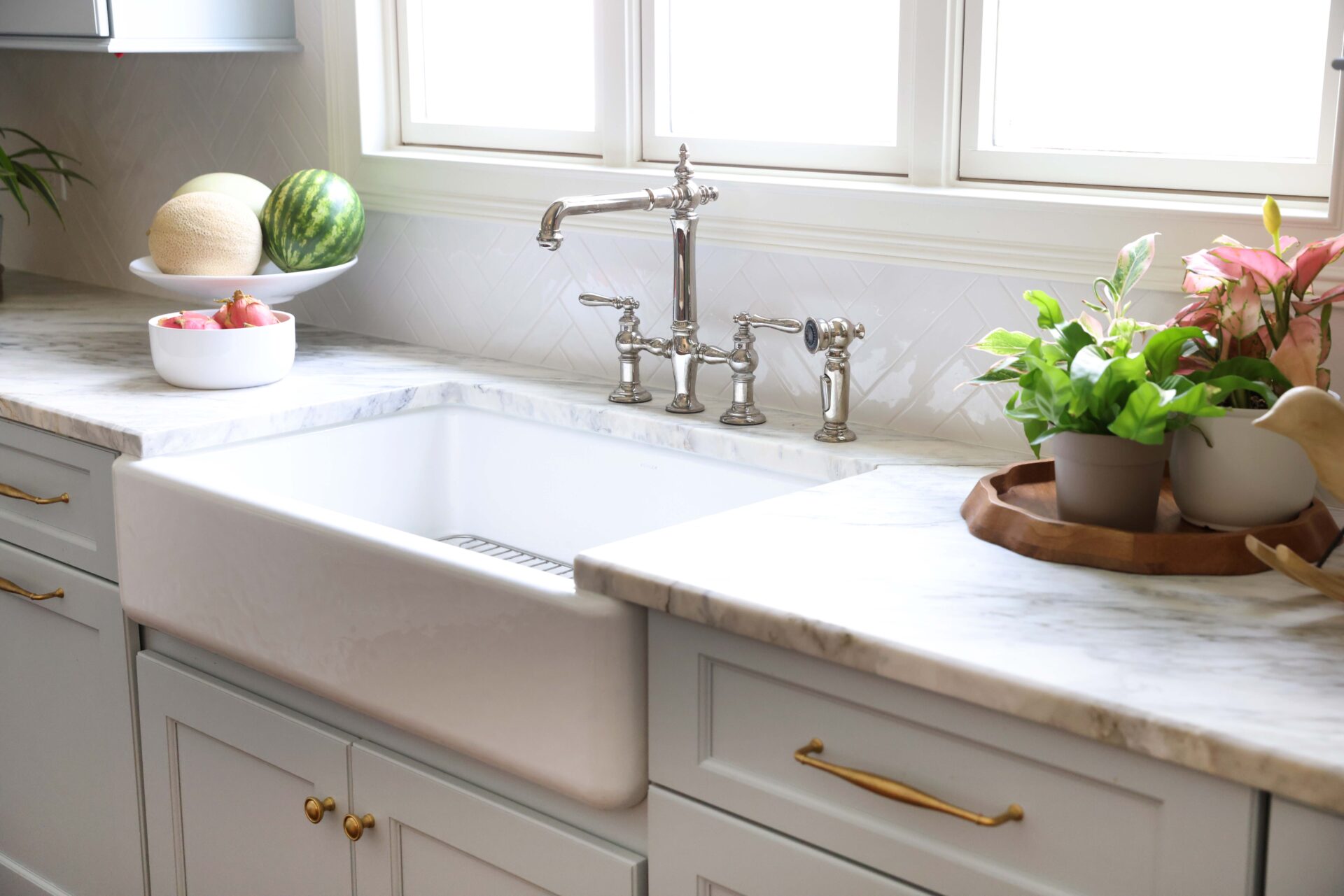 White apron front sink in a light blue traditional kitchen
