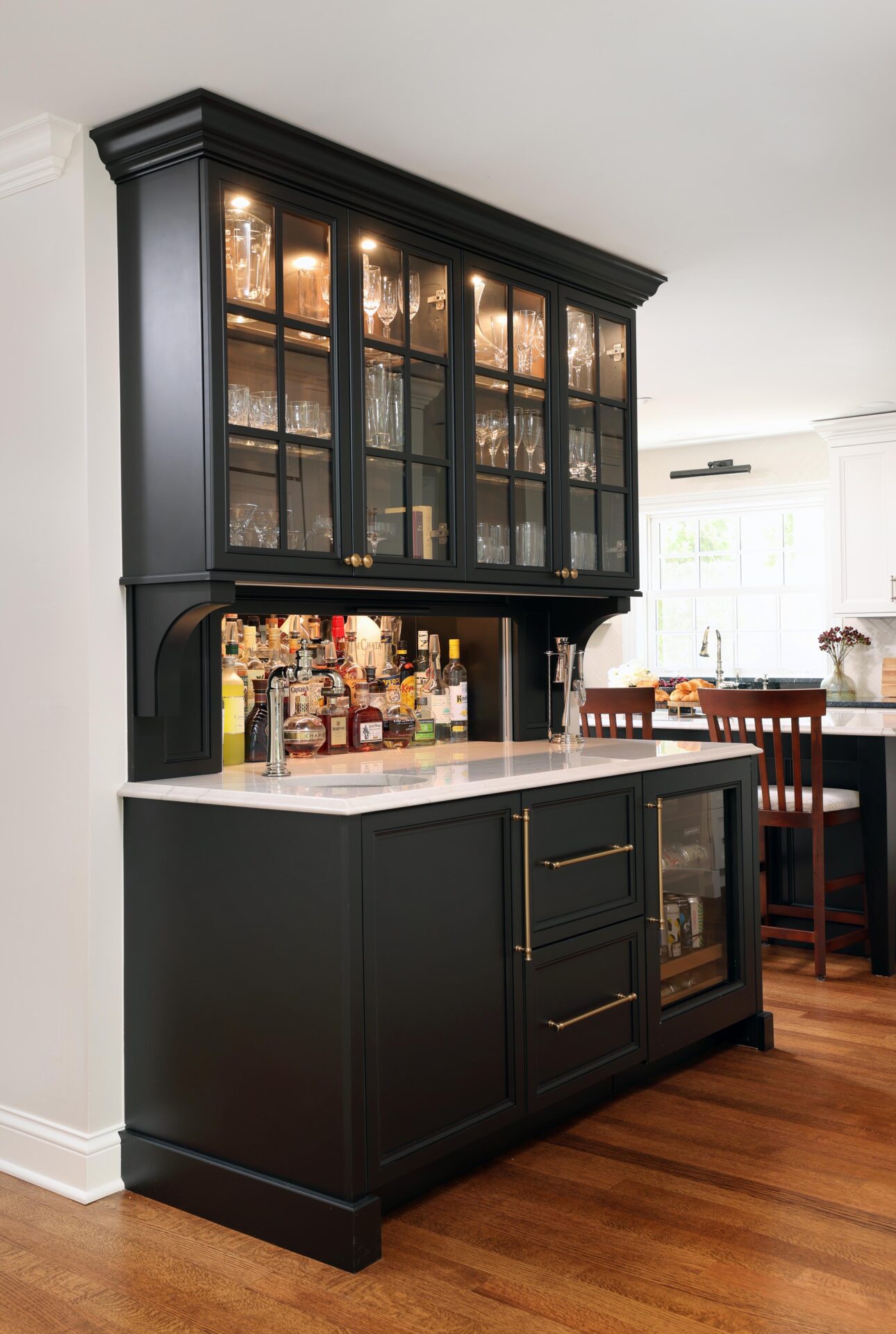 Home bar with black cabinetry, beverage fridge, glass-paneled upper cabinets, hidden appliance garage for liquor