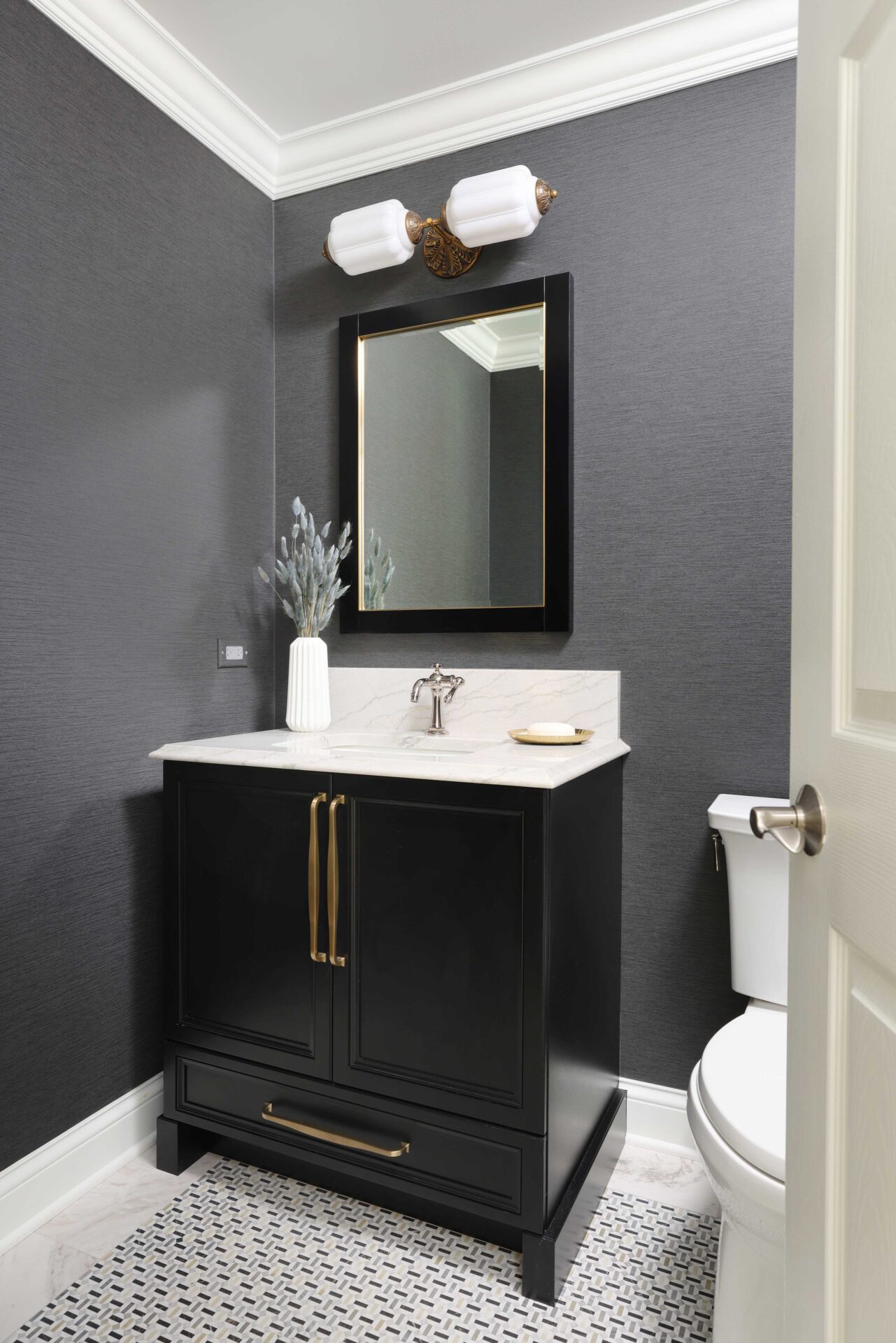 Powder room, black vanity, patterned floor tile White countertops, gray walls, decorative light above mirror